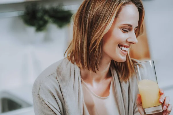 Señora alegre está tomando un vaso de bebida fresca — Foto de Stock