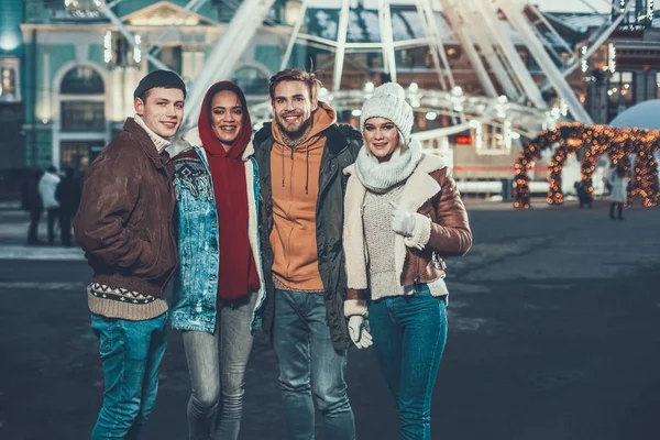 Quatre jeunes amis souriant tout en se tenant dehors ensemble — Photo