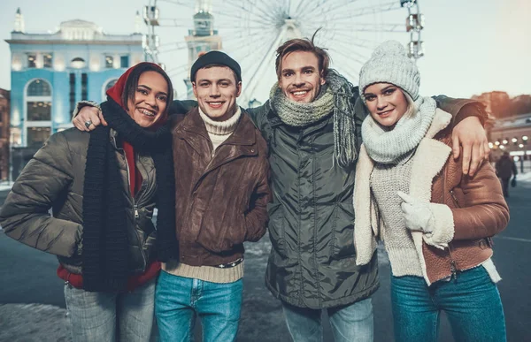 Taille haute de quatre jeunes amis debout dans des vêtements chauds à l'extérieur — Photo