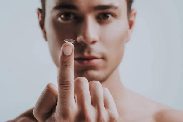 Selective focus of contact lens on finger of man