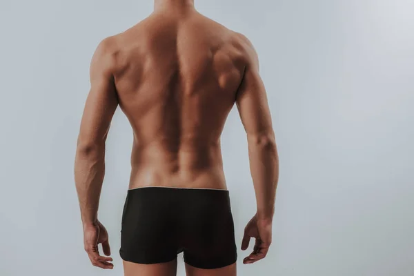 Back of muscular man in black underwear standing alone — Stock Photo, Image