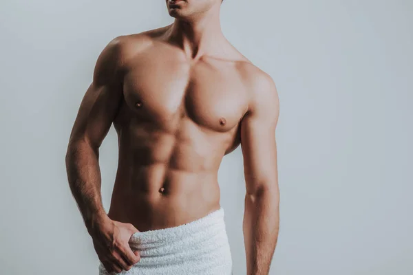 Hombre musculoso con toalla blanca en las caderas y de pie solo — Foto de Stock