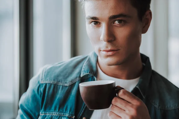 Portrait of calm man standing with his cup