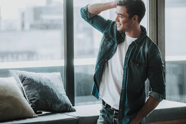 Pencerenin duran ve onun saç dokunmadan duygusal adam