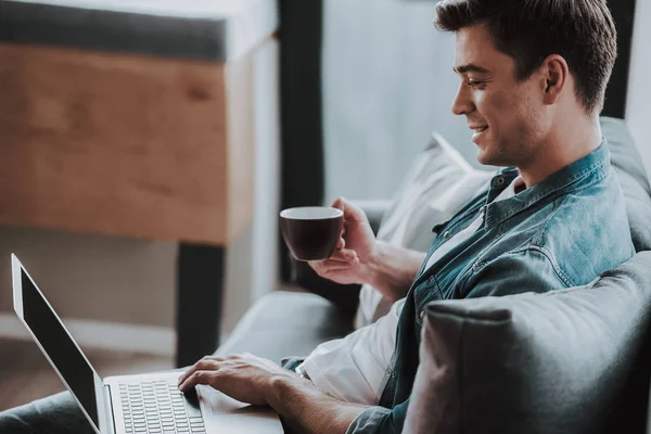 Confident man drinking coffee while working at home