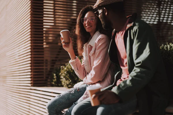 Sonriente pareja amada sentarse en balaustrada de madera — Foto de Stock