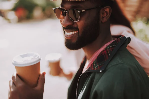 Close up van glimlachende man zitten buiten op een zonnige dag — Stockfoto