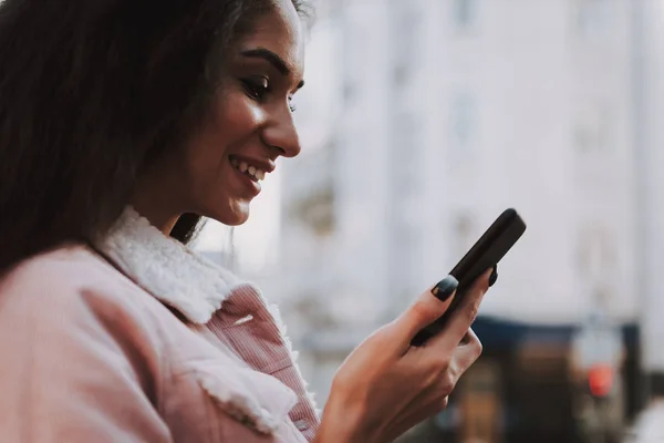 Lato ritratto di signora sorridente con cellulare — Foto Stock