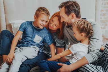 Mutlu anne ve iki çocuğu birlikte kucaklayan