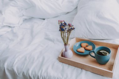 Bir fincan çay ve bisküvi his yatak üzerinde