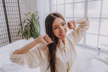 Asyalı kadın rahat yatak odasında kirlenmiş gülümseyen mutlu