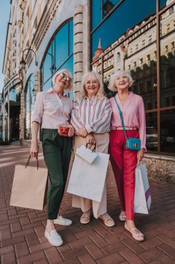 Smiling old ladies are standing near mall clipart