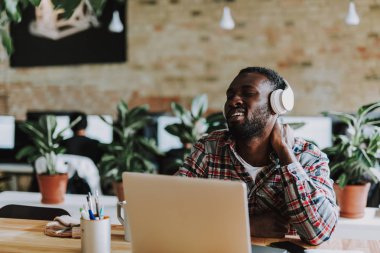 Genç adam onun boynunu laptop ile masada otururken sürtünme