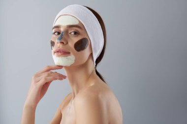 Yüz maskeleri farklı türleri kullanarak çekici genç bayan