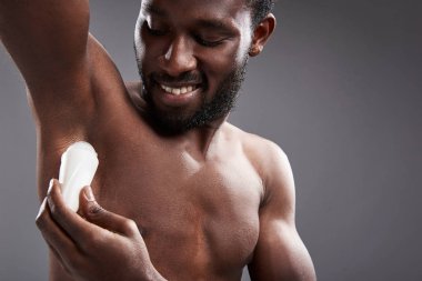 Neşeli yakışıklı afro Amerikalı adam onun deodorant kullanarak