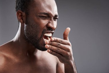 Genç afro Amerikalı adam gri arka plan üzerinde hapşırma