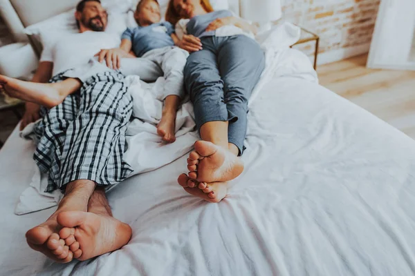 Madre y padre durmiendo con un niño en la cama — Foto de Stock