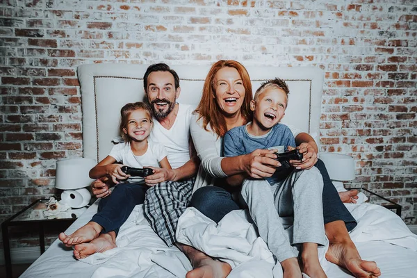 Família feliz jogando no console do jogo e se divertindo — Fotografia de Stock