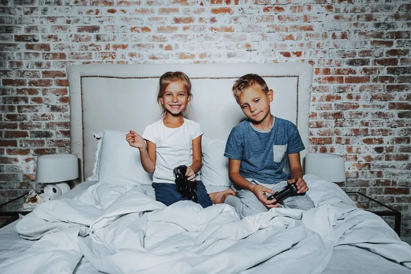 Liten pojke och flicka som leker med spelkonsol — Stockfoto