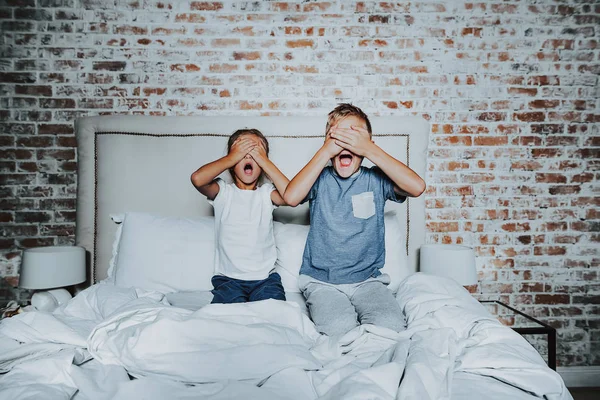 Bror och syster dölja ögon med händerna — Stockfoto