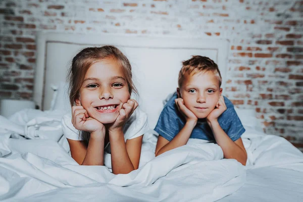 Kleine jongen en meisje samen op bed te leggen — Stockfoto