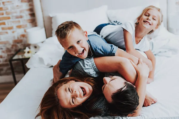 Vrolijke man en vrouw plezier met kinderen — Stockfoto