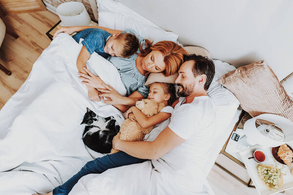 Top view happy family sleeping together in bed