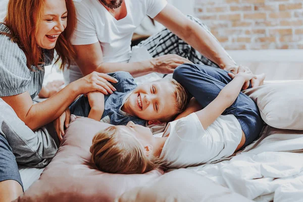 Gelukkige kinderen lachen tijdens het spelen met ouders — Stockfoto