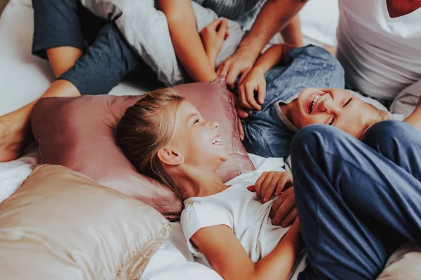 Bambini felici ridendo mentre giacevano a letto — Foto Stock
