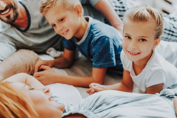 Fechar a menina feliz e menino com os pais na cama — Fotografia de Stock