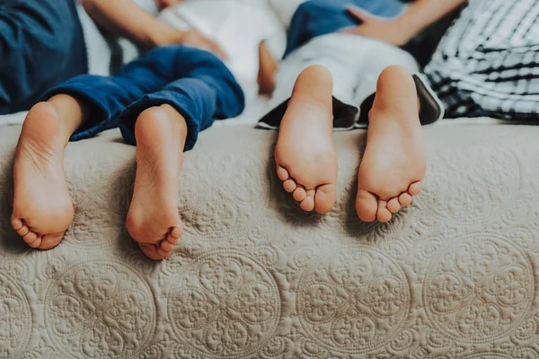 Närbild på två fotpar barn i sängen — Stockfoto
