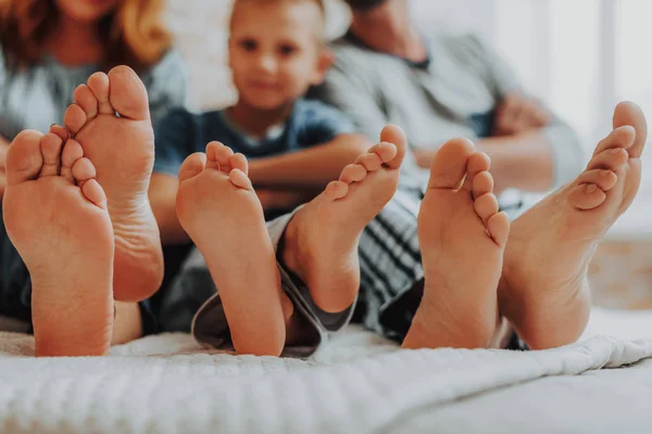 Close-up van familie drie paren van voeten in bed — Stockfoto