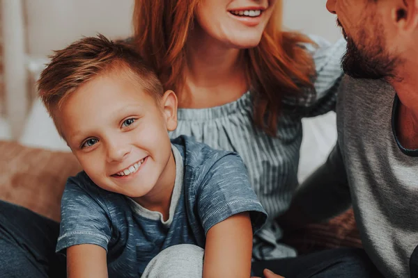 Gelukkige zoon zittend op bed samen met ouders — Stockfoto