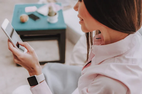 Happy asian lady watching at mobile phone in apartment