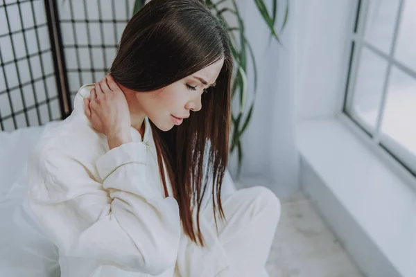 Disappointed asian woman expressing pain near window — Stock Photo, Image