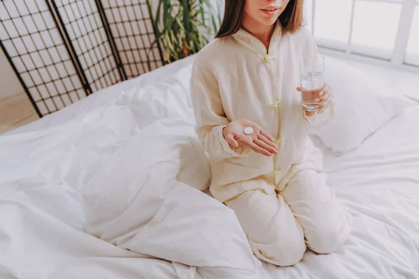 Young woman taking vitamin tablet in her hand — Stock Photo, Image