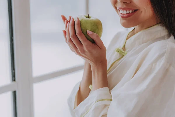 Donna sorridente degustazione deliziosa mela in appartamento — Foto Stock