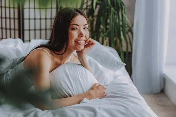 Affascinante donna asiatica guardando la fotocamera sul letto — Foto Stock