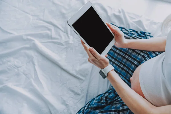 Jovem futura mãe lendo eBook no quarto — Fotografia de Stock