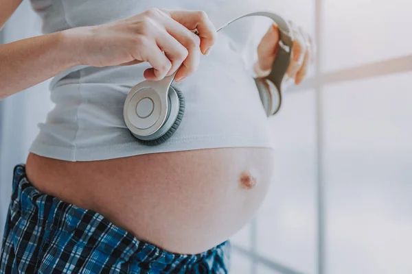 Donna in attesa sta godendo la musica a casa — Foto Stock