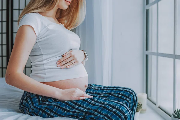 Futura madre relajante cerca de la ventana en casa — Foto de Stock