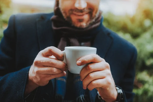 Sonriente hombre está disfrutando de la bebida caliente al aire libre —  Fotos de Stock