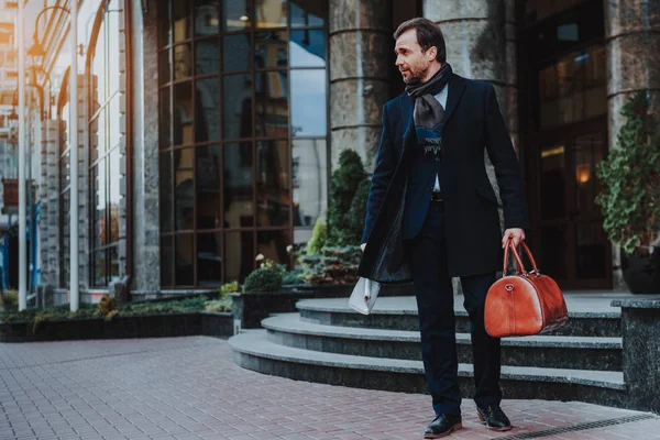Stylish businessman is walking in urban street