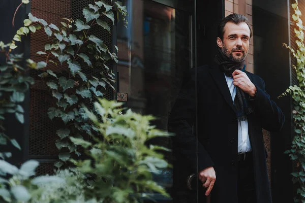 Tranquilo hombre con estilo en abrigo negro está saliendo — Foto de Stock