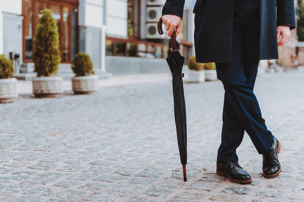 Homme élégant en manteau noir tient parasol — Photo