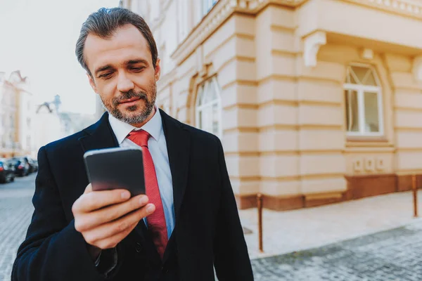 Biznesmen jest za pomocą telefonu komórkowego, w mieście — Zdjęcie stockowe