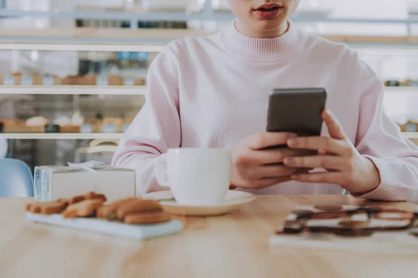 カフェで彼女の電話を使用して素敵な若い女性 — ストック写真