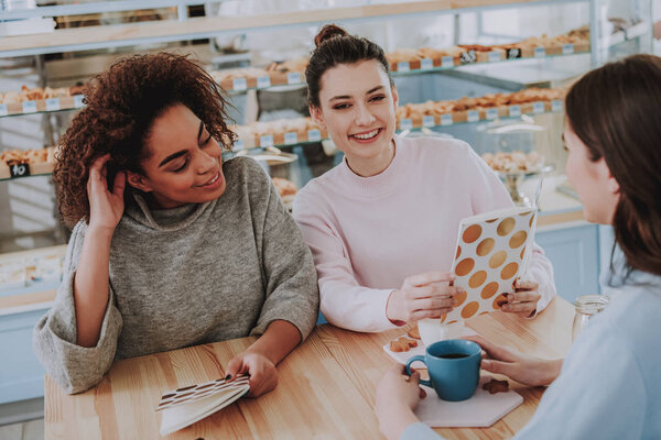 Cheerful girls meeting in the cafe on the weekend