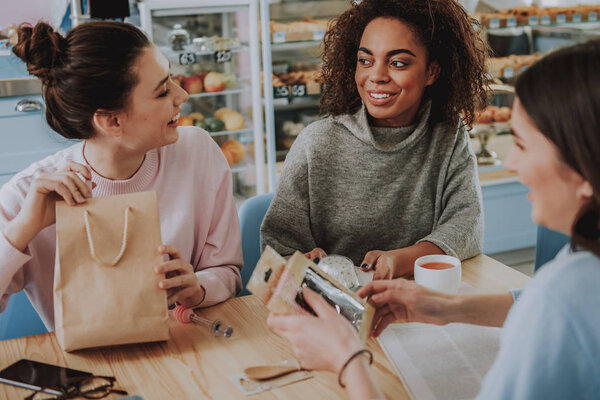 Positive female friends resting in the cafe