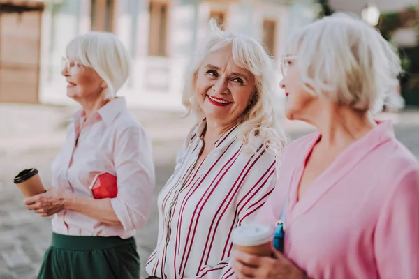 Drei ältere Freundinnen spazieren durch die Stadt — Stockfoto